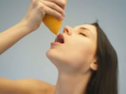 Обнаженный подросток пьет апельсиновый сок